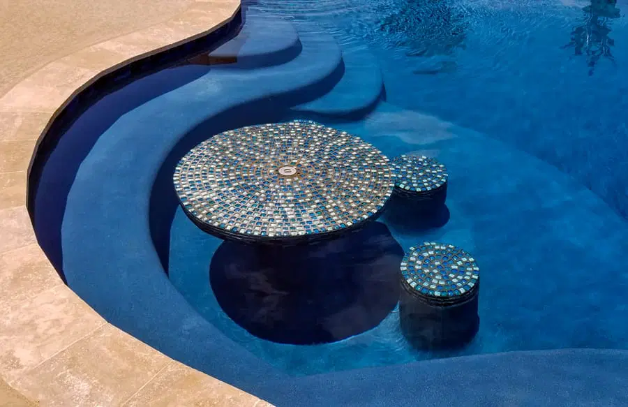 Tiled swim-up table and stools inside a Houston custom pool.